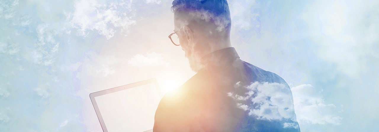 A man looking at the laptop screen in sunlight