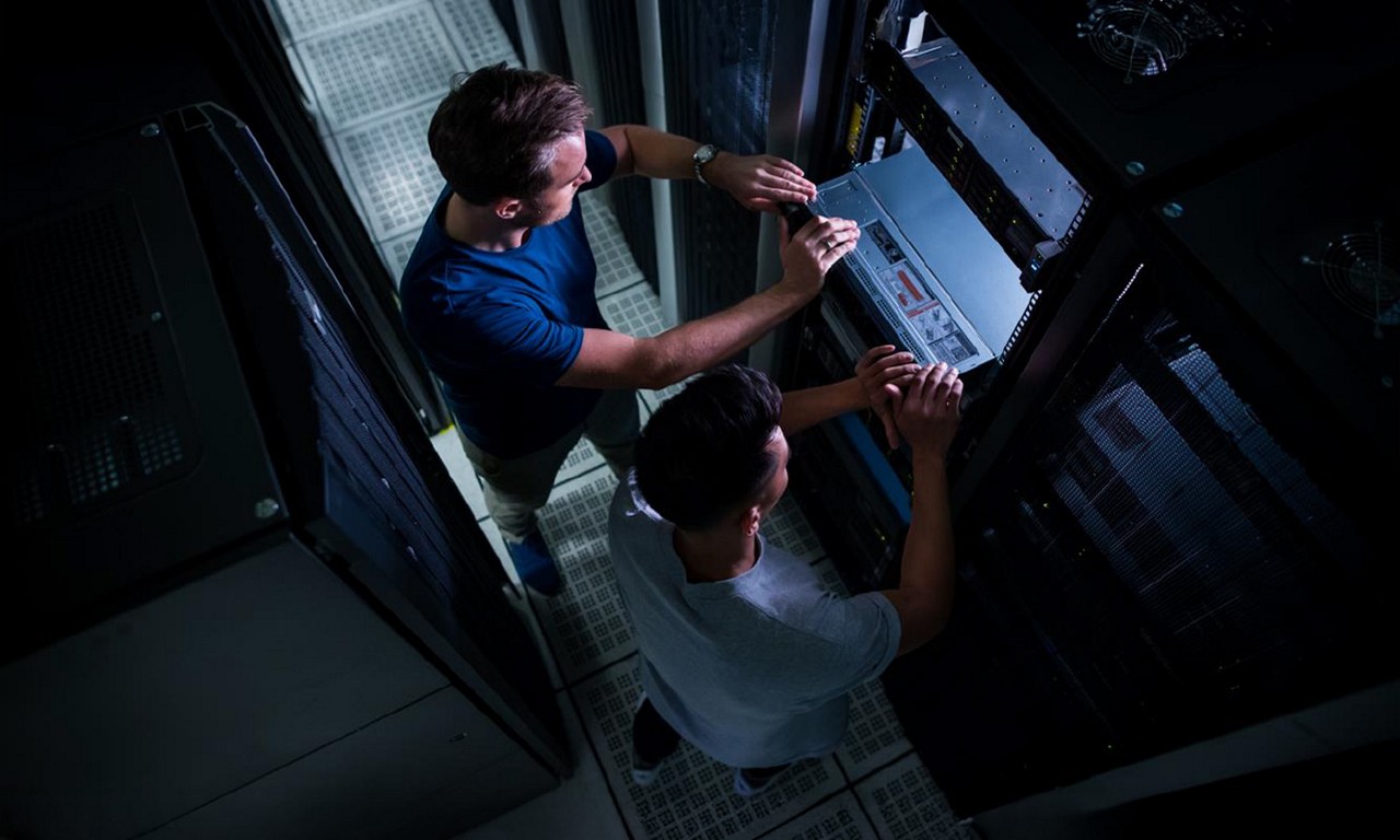 Two men using a machine in the lab