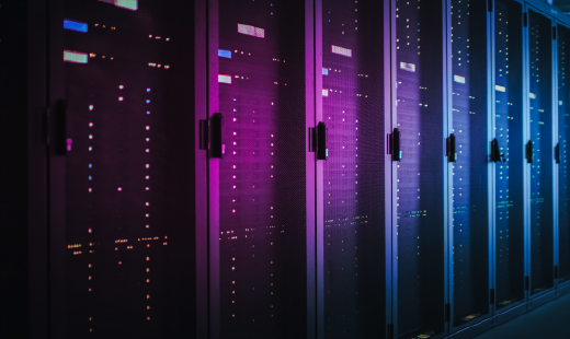 row of lit-up server banks in a dark data center