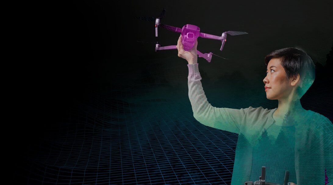 woman holding a fuchsia drone up in the air with one hand 