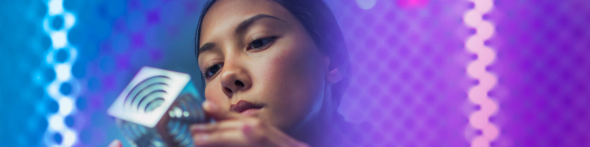 woman engineer looking at cube blue purple background
