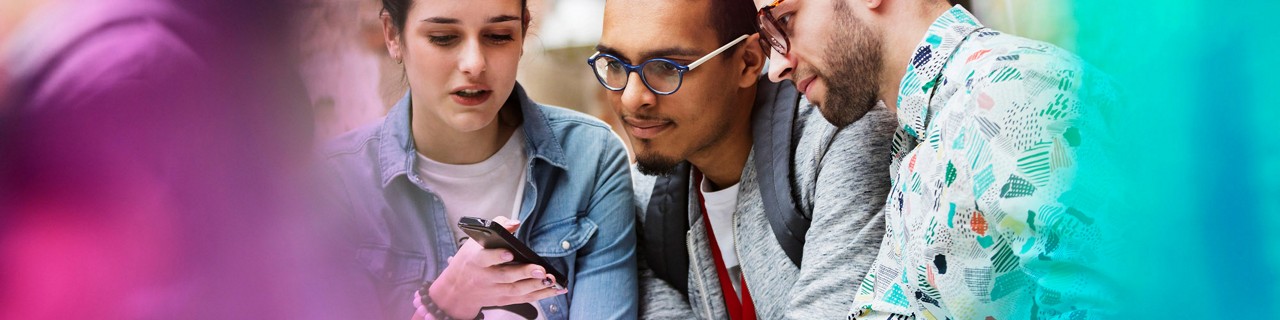group of young adults looking at a smartphone