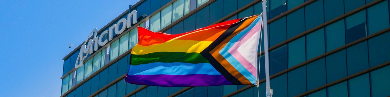Micron logo on building with pride progress flag in the front